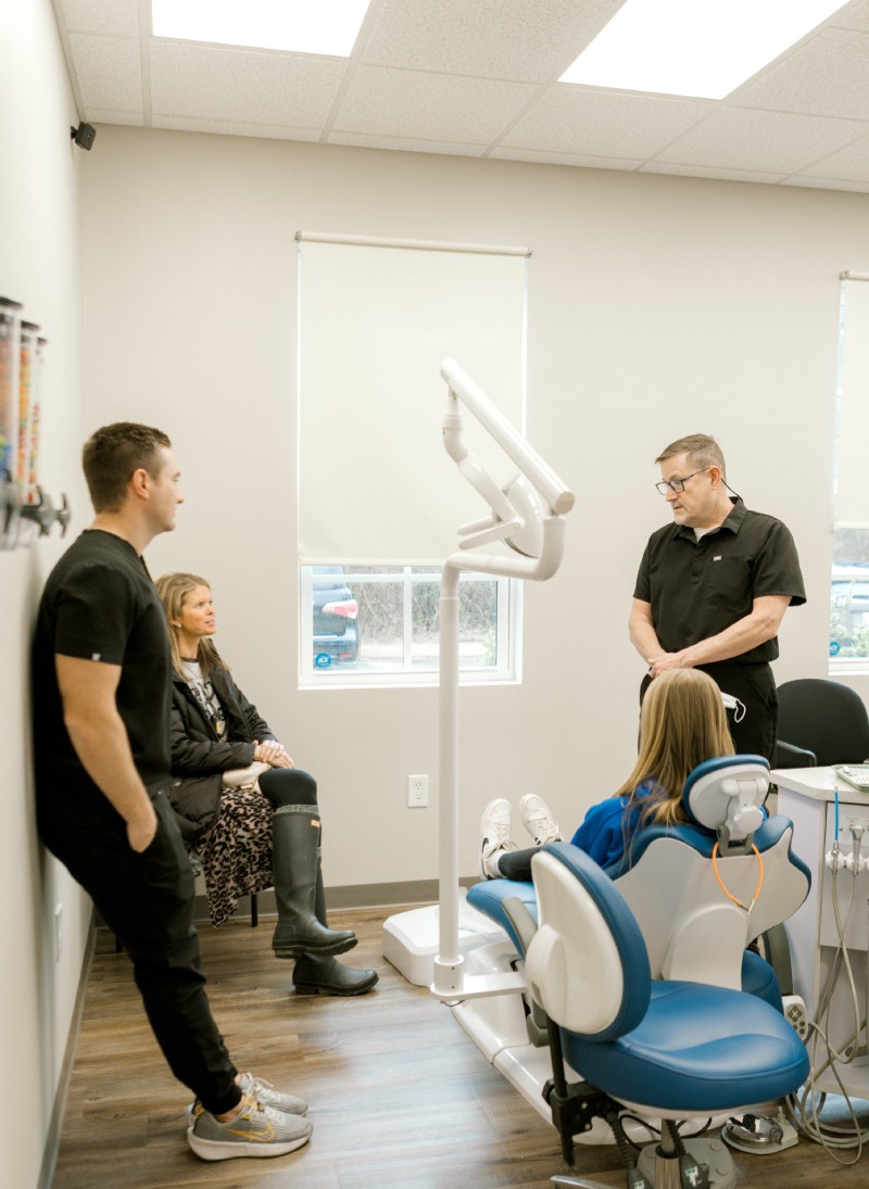 Orthodontist reviewing a treatment plan with a young patient and her parent at Hometown Orthodontics